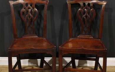 A pair of George III red walnut/mahogany hall chairs, each w...