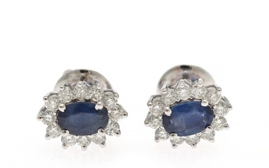 A pair of sapphire and diamond ear studs each set with an oval-cut sapphire encircled by diamonds, mounted in 14k white gold. (2)