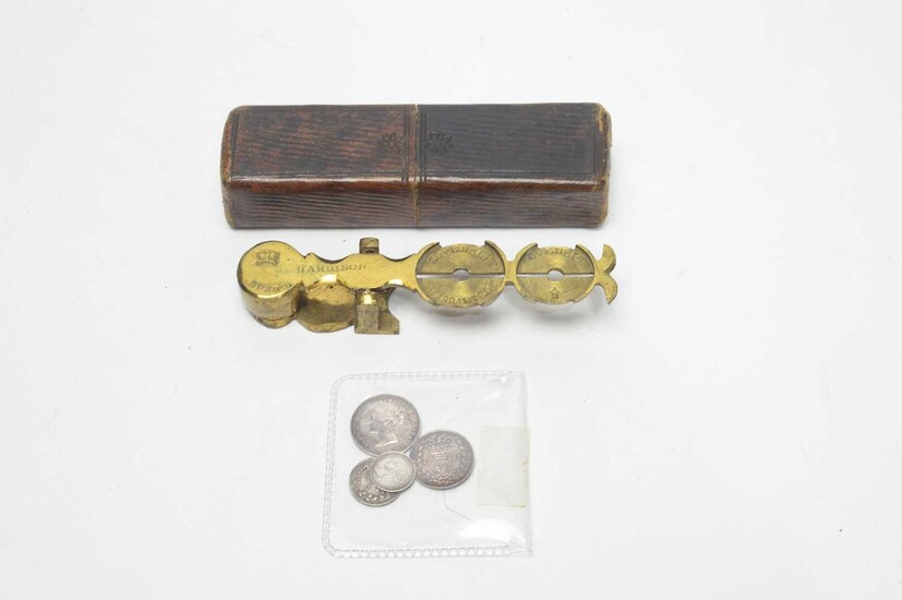 A set of brass sovereign scales and silver coins.