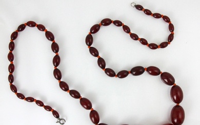 A string of cherry coloured 'amber' beads, the fifty graduat...