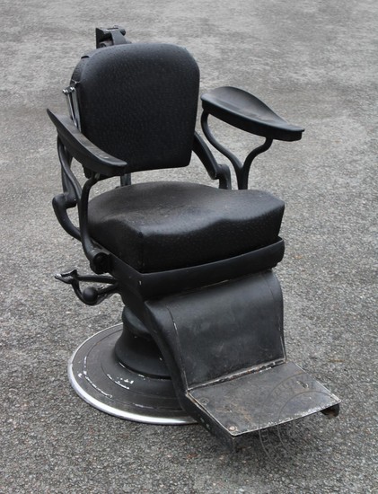 A vintage black leather and painted metal barbers chair, the...