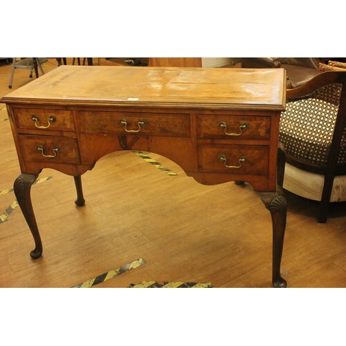A walnut kneehole dressing table, fitted five drawers, on oa...