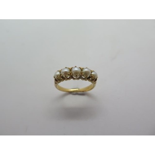 A yellow gold ring set with five pearls, no hallmark but tes...