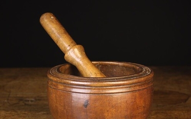 An 18th Century Turned Treen Pestle & Mortar. The pestle having a pole handle pierced with a string