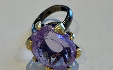 An amethyst ring set with an oval-cut amethyst mounted in partly gilded and oxidized sterling silver. Size 57.