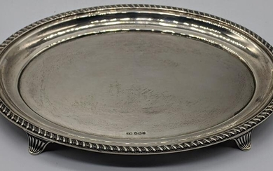 An early 20th century silver oval stand, raised on four