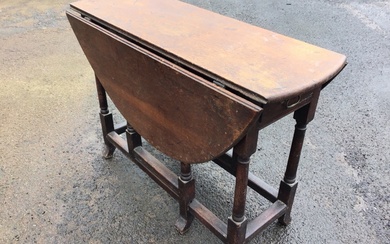 An eighteenth century oak dining table with two rule-jointed drop...