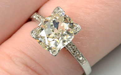 An oval-shape old-cut diamond single-stone ring, with diamond line shoulders.