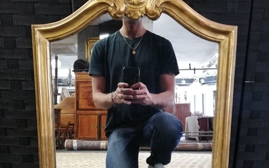 Petit miroir en bois mouluré, sculpté et doré à décor d’une coquille. Epoque XX°. 71x44cm...