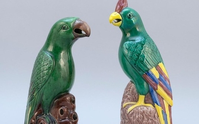 TWO CHINESE POLYCHROME PORCELAIN PARROT FIGURES Standing on aubergine rockery bases. Heights 10" and 11".