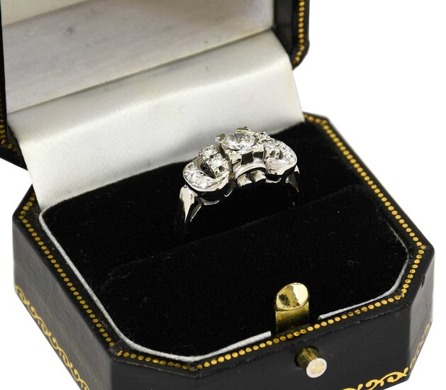 A diamond cluster ring, the buckle motif set throughout...