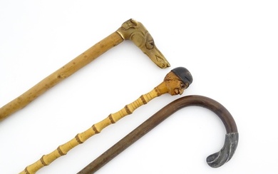 Three 20thC walking sticks / canes comprising one with a car...
