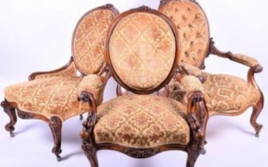 A large Victorian upholstered carved walnut armchair and two others with scrolled arms and legs supported on cabriole legs,...