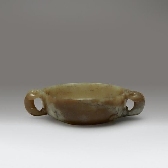 A Chinese carved yellow, beige, and grey jade circular