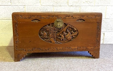 A Chinese style camphor carved chest, the top with carved relief panel depicting travellers
