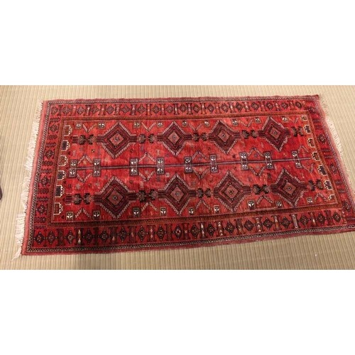A MIDDLE EASTERN WOVEN WOOLLEN PIGEON RED GROUND FLOOR CARPE...
