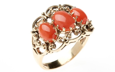A NOUVEAU STYLE CORAL RING; set in a 9ct gold scrolling mount with 3 oval cabochon corals, size N, top 14 x 18mm, wt. 4.3g.