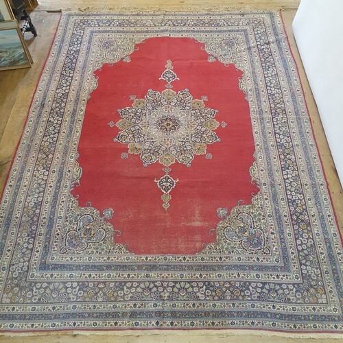 A Persian red ground carpet with multiple borders, centre wi...
