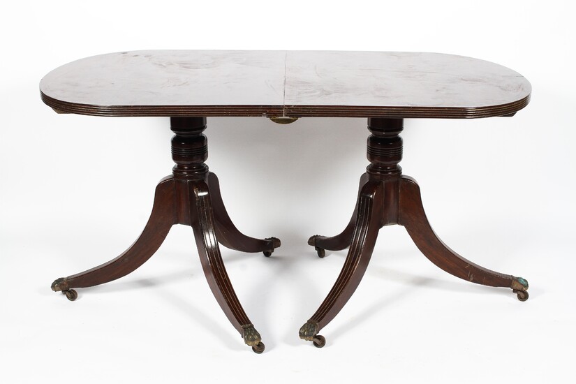 A Regency style mahogany twin pedestal dining table, with reeded d-shaped ends