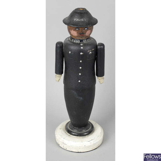 A carved and painted wooden folk art lamp base modelled as a police officer.