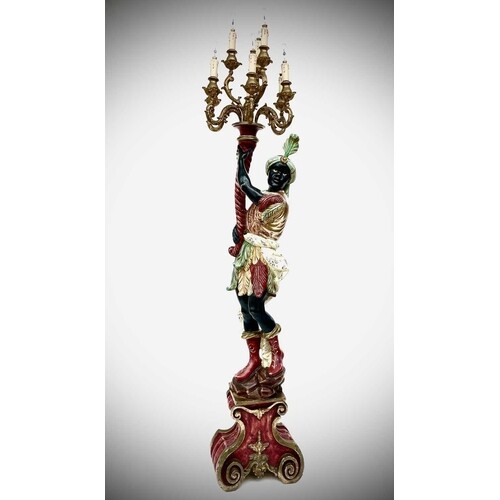A carved, painted and gilt floor standing figural candelabra...