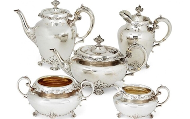 A five-piece Victorian silver tea service, London, c.1899, Goldsmiths & Silversmiths Company (hot water pot c.1900), of oval form, the body of each raised on four scroll feet to foliate shoulders, the shaped rims decorated with repeating c-scroll...