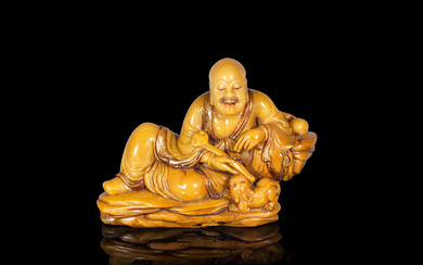A gilt-decorated soapstone carving of the Laughing Lion Luohan