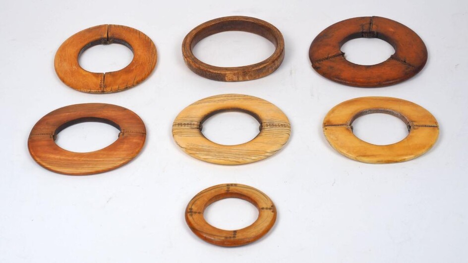 A group of large mixed African ivory bangles, 19th century, of varying patinas an sizes, some with additional decoration and various traditional repairs, largest 8cm wide (5)