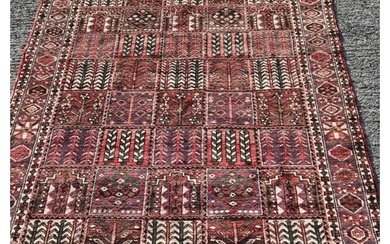 A hand woven Persian Bakhtiari Carpet with a traditional pan...
