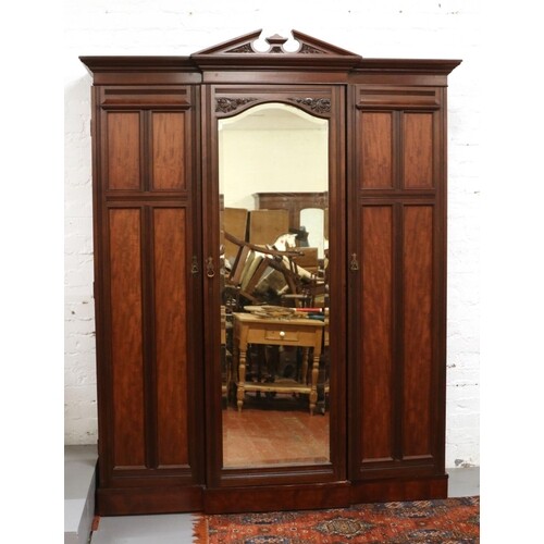 A late Victorian mahogany triple mirror front wardrobe. With...