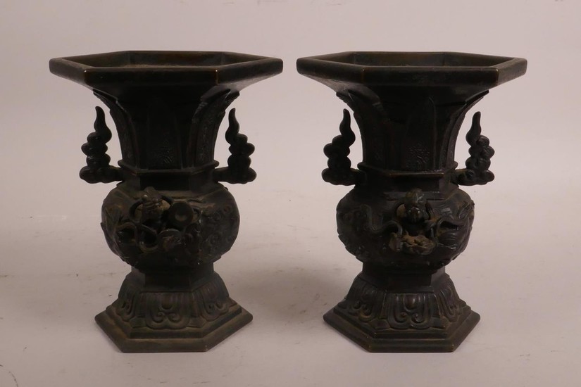 A pair of Oriental bronze two handled vases with raised deit...