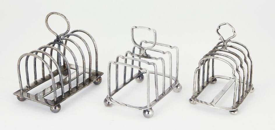 A silver five bar toast rack, Birmingham, c.1946, Hukin & Heath, the shaped, rounded bars to loop handle, raised on four ball feet, 8.9cm long, 10cm high, together with two silver plated toast racks, one by Mappin & Webb, weighable weight approx...