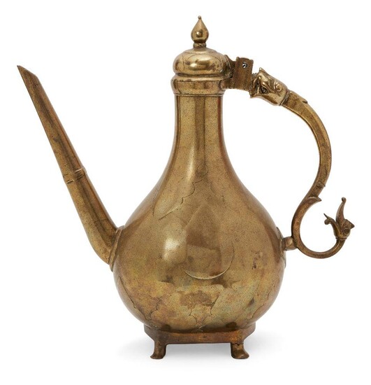 A unusually large cast brass lidded ewer, Mughal India, 18th century, the pear-shaped body on pedestal base standing on four small feet, with a straight spout and serpentine handle with dragon and lion-head terminals, including a hinged domed...