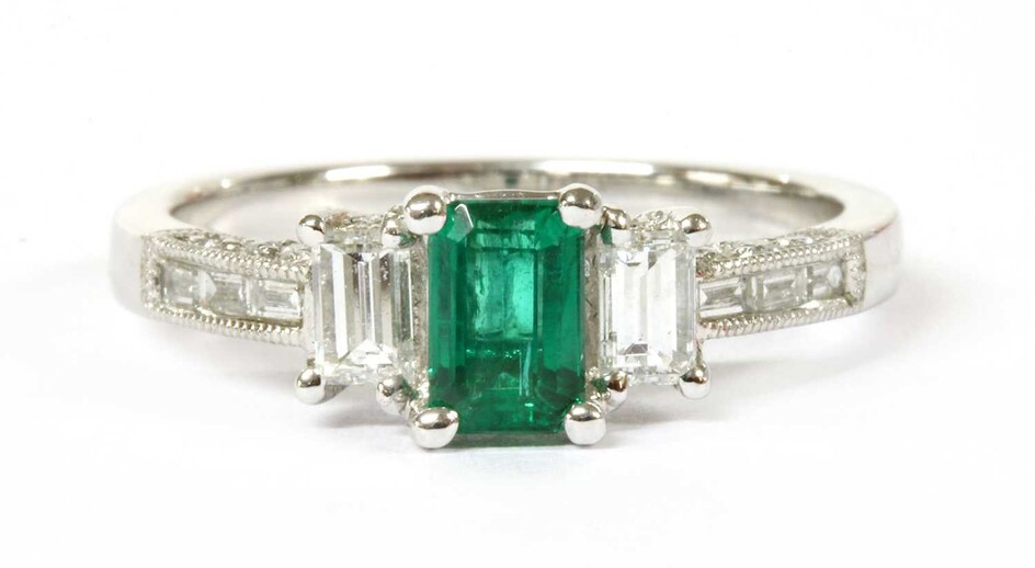A white gold emerald and diamond three stone ring
