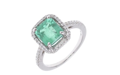 AN EMERALD AND DIAMOND CLUSTER RING. the rectangular-shaped ...