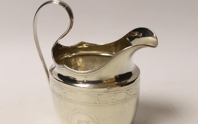 An early 19th century Irish engraved silver cream jug, crown...