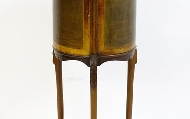 An early 20thC mahogany jardinière with a barrel top raised on three carved cabriole legs