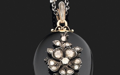 Collier en métal orné de pierres d'imitations retenant un pendentif médaillon ouvrant de forme ovale...