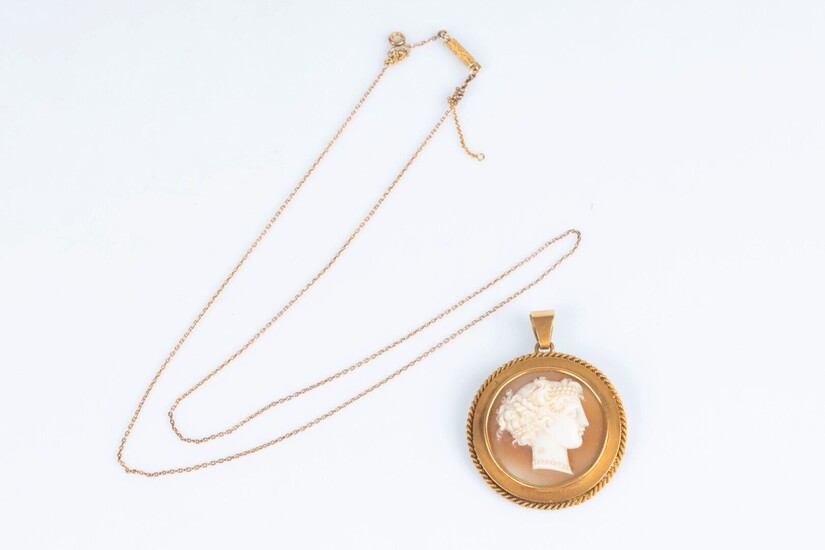 Pendentif en or sertie d'un camée coquille gravé d'un profil de femme à l'antique. XIXème...