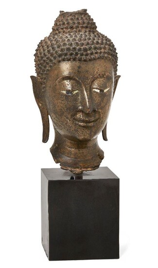Property of a Gentleman (lots 36-85) A large bronze head of Buddha Shakyamuni, 17th/18th century, cast with serene expression and downcast eyes, with elongated earlobes, 24cm high, metal stand