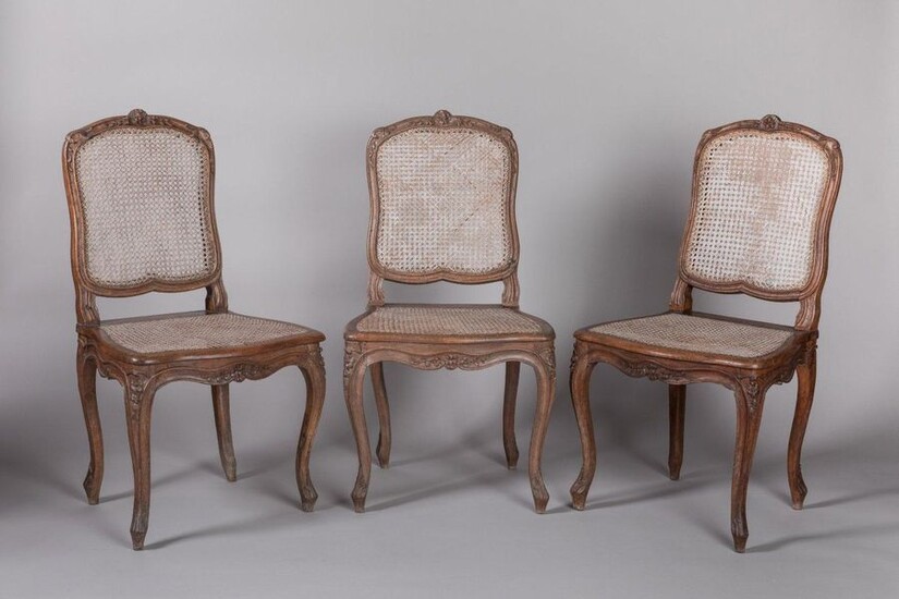 THREE CANNED CHAIRS by TILLIARD in moulded and sculpted beech wood, the violin-shaped backrest decorated with cushioned flowers surrounded by foliage garlands, the shoulder decorated with acanthus scrolls. The scrolled belt has in the centre of the...