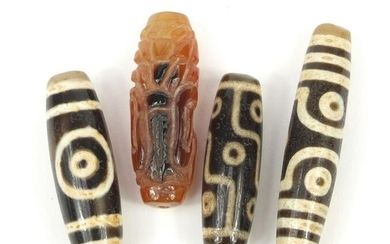 Three Tibetan agate beads and one other, the largest