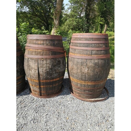 Two oak barrels with metal banding. {133 cm H x 80 cm Diam}.