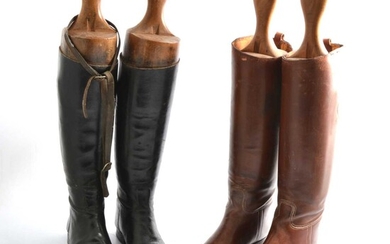 Two pairs of riding boots with trees, one pair black and one pair brown.
