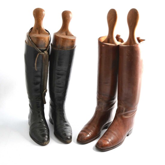 Two pairs of riding boots with trees, one pair black and one pair brown.