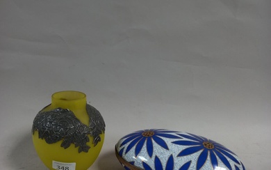 Une boîte ovale en porcelaine et monture en laiton à décor de fleurs stylisées, marque...