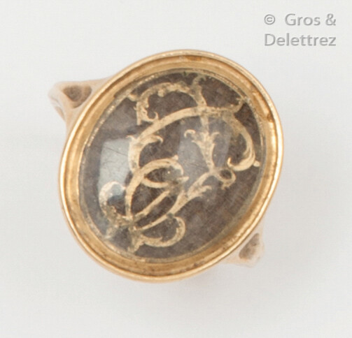 Yellow gold ring, decorated with a number surmounting a plate of braided hair. Work from the end of the 18th century. Finger size : 49. Gross weight : 3,7g.