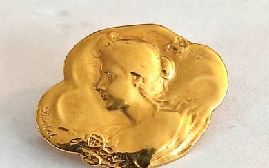 18 kt yellow gold brooch depicting a female face. Signed...