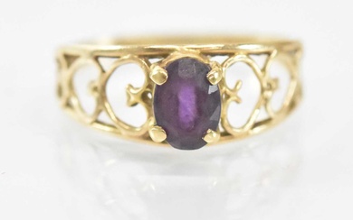 A 14ct yellow gold ring set with central purple stone,...