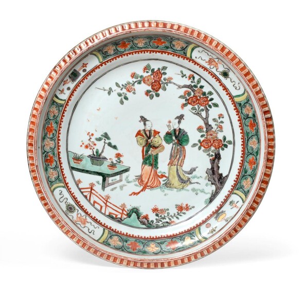 A Chinese Porcelain Charger, Kangxi, painted in famille verte enamels with figures in a fenced...